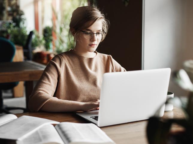 egy nő a laptopján dolgozik