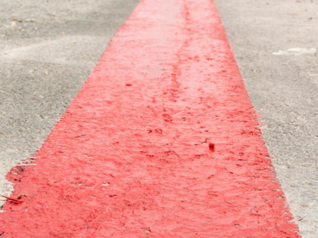 Egy piros vonal az aszfalton