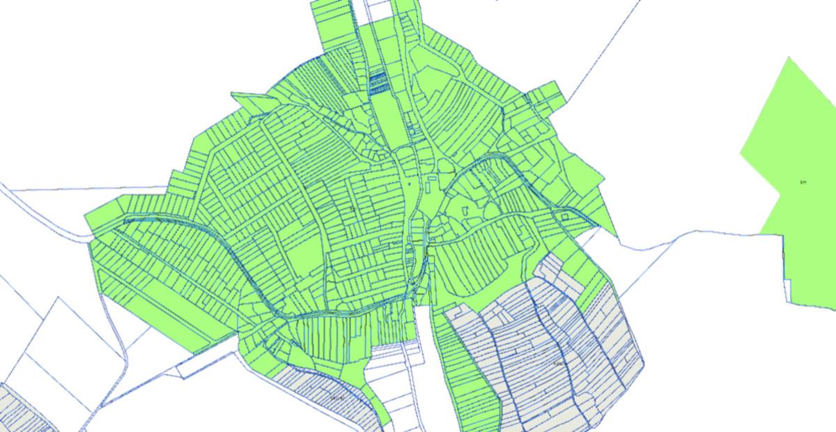 Települési térkép, amelyen utcahálózat és területhasználati zónák láthatók zöld és kék színekkel jelölve.